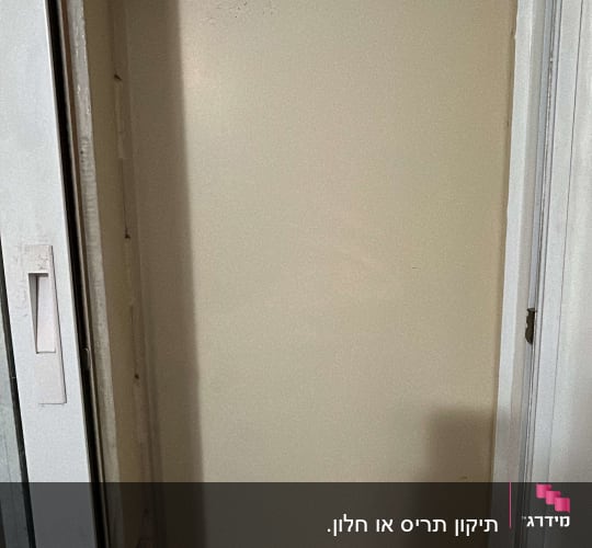 חלון עם תריסים סגורים ומסגרת מתכתית